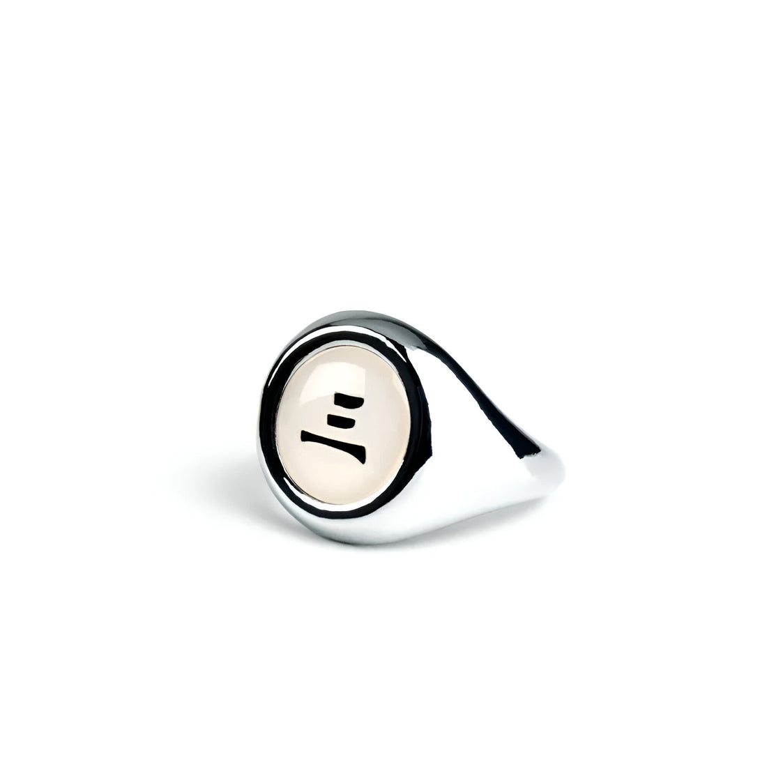 Bague en argent avec le symbole du village caché des feuilles sur un fond blanc.