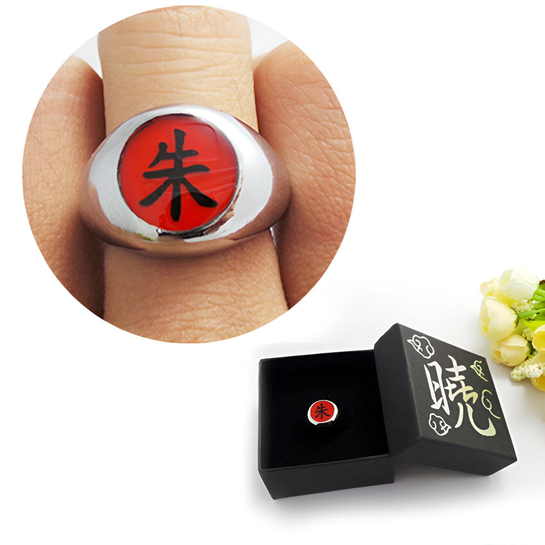 Bague Naruto en métal argenté avec un insigne rouge et noir représentant le symbole "木" (bois) dans une boîte noire.