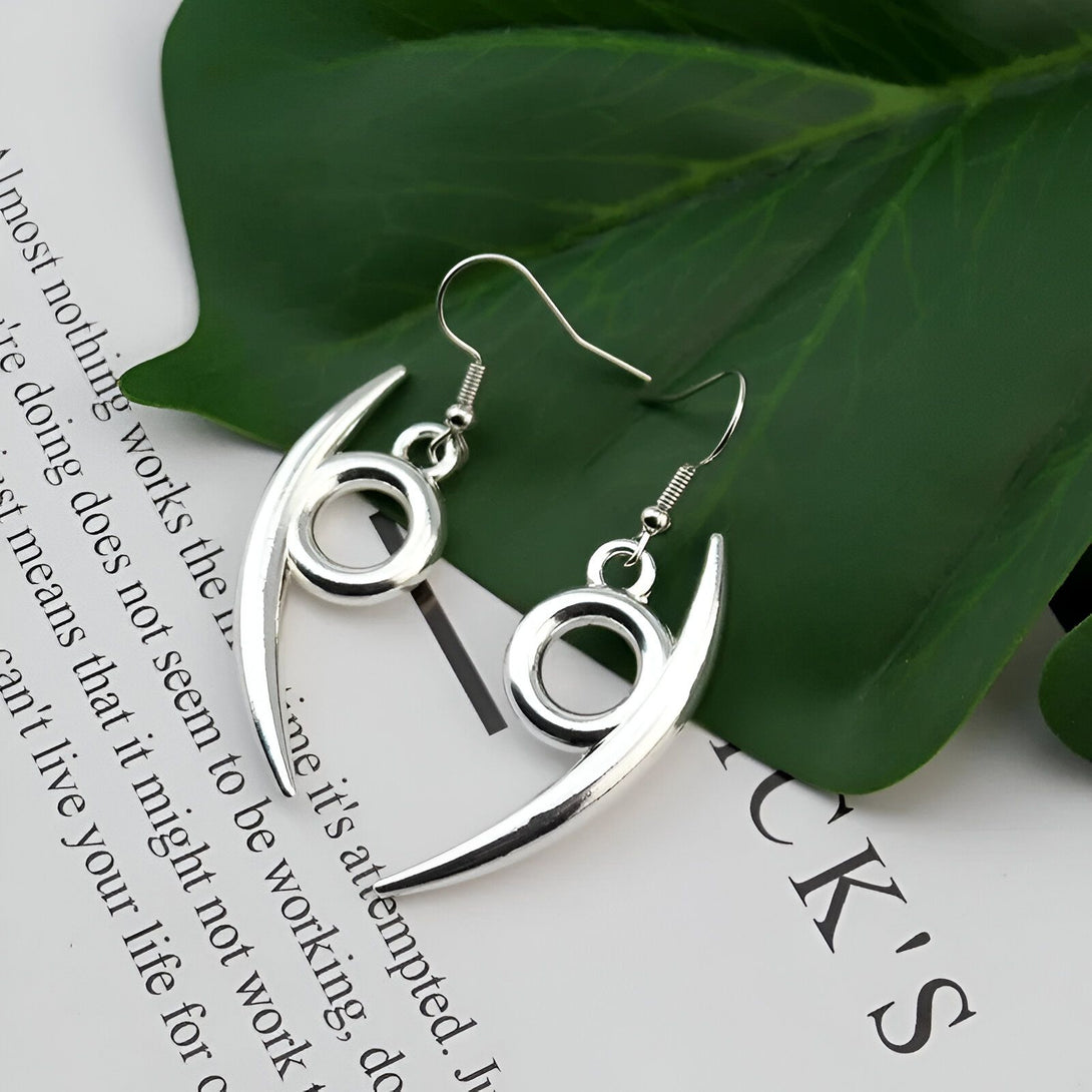 Boucles d'oreilles argentées en forme de croissant de lune avec un cercle au centre, inspirées de l'univers de Naruto.  Ces boucles d'oreilles sont un excellent moyen d'afficher votre amour pour l'anime.