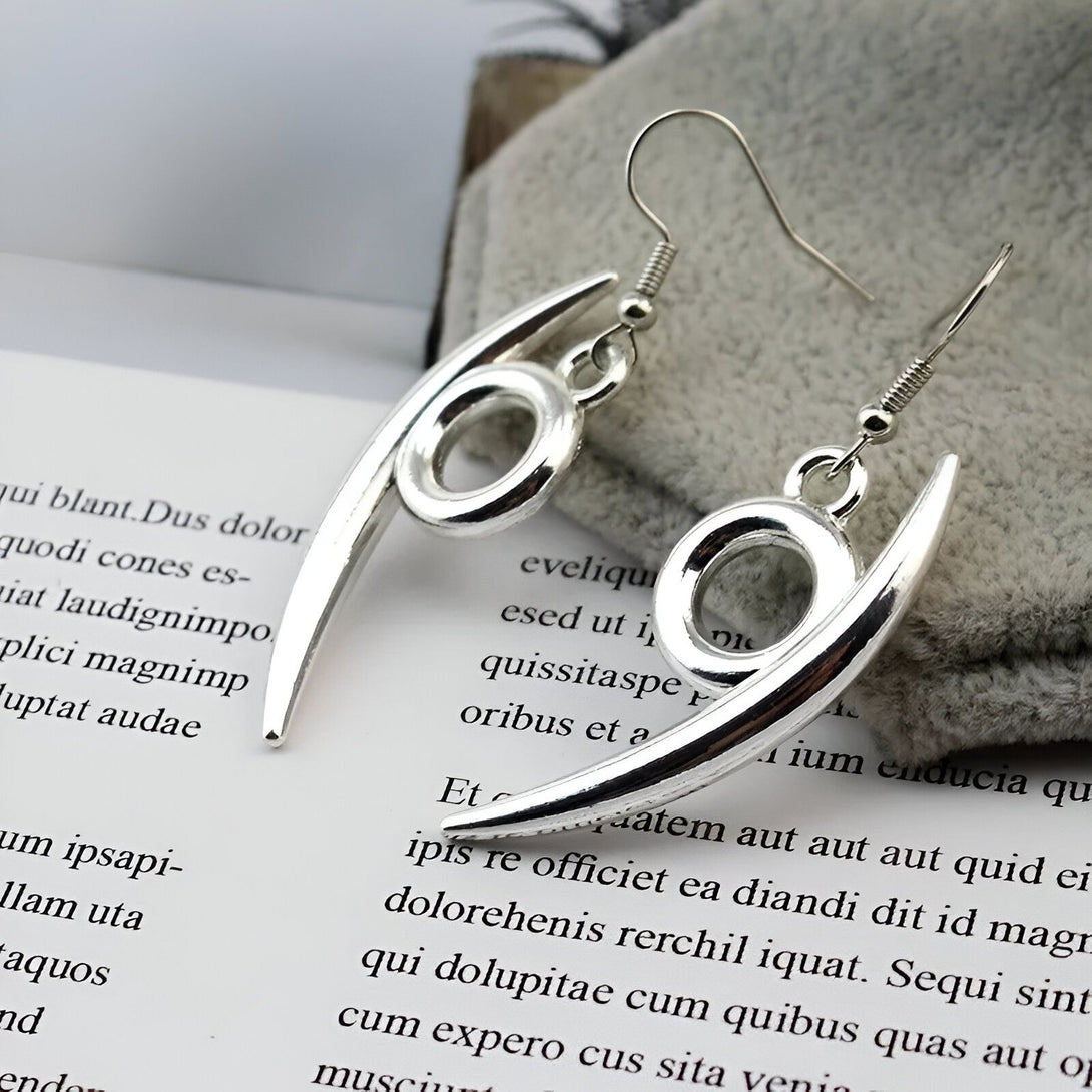 Une paire de boucles d'oreilles en argent en forme de griffes de Sharingan, symbole emblématique du manga et de l'anime Naruto. Ces boucles d'oreilles sont un excellent accessoire pour les fans de Naruto et ajouteront une touche unique à votre style.