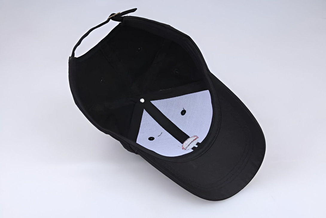 Casquette noire en coton avec un design brodé sur le devant. La casquette est vue de l'intérieur, montrant la couture et la visière.