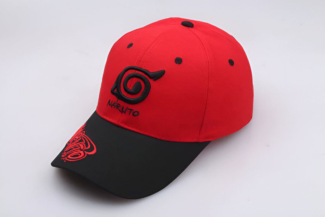Casquette rouge avec le logo de l'organisation de Konoha "Hokage" et le mot "Naruto" en noir brodé sur le devant. La visière est noire.