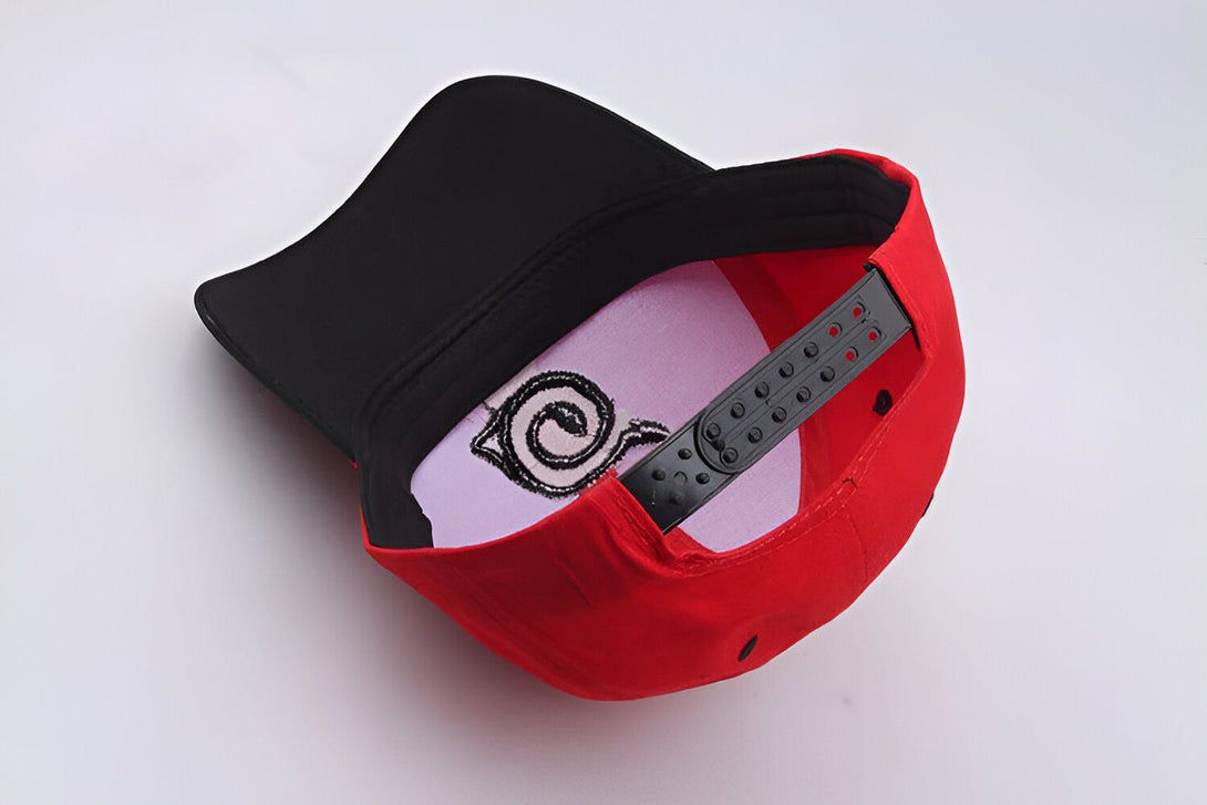 Casquette rouge avec un logo blanc brodé, une visière noire et une fermeture à boucle réglable.