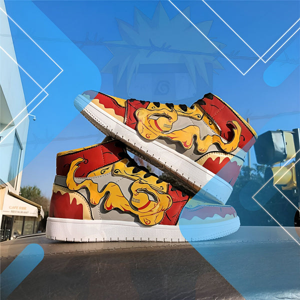 Une paire de chaussures de sport haute avec un motif Naruto. Les chaussures sont rouges et jaunes avec des éclaboussures de peinture orange et noire. Le logo Naruto est visible sur le côté des chaussures.