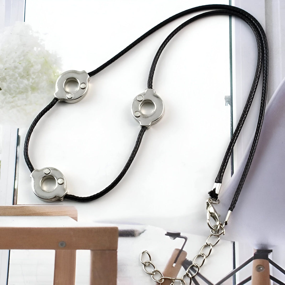 Collier Naruto avec trois anneaux argentés et une corde noire.