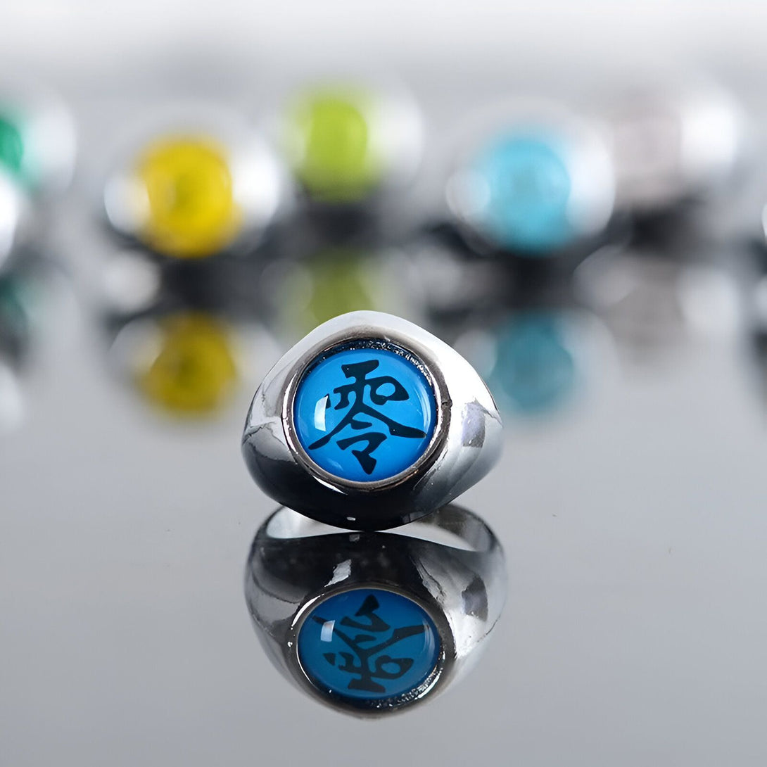 Bague de Sharingan bleue avec le symbole "Sharingan" en noir sur un fond réfléchissant.