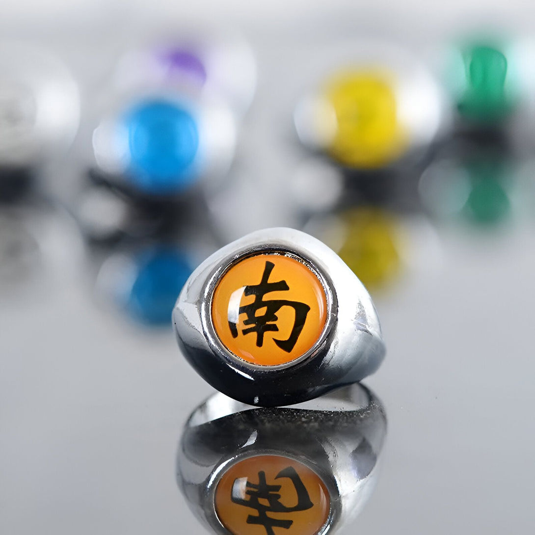 Bague en métal argenté avec un symbole orange et noir représentant le clan Uchiwa de l'anime Naruto.