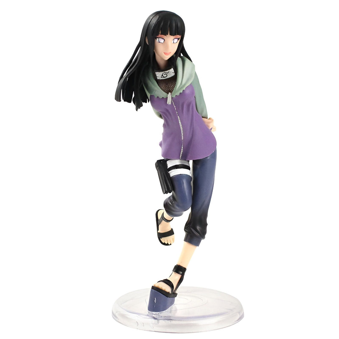 Figur de Hinata Hyuga du manga Naruto, debout sur un socle transparent, vêtue d'une veste violette et d'un pantalon bleu, avec ses longs cheveux noirs.
