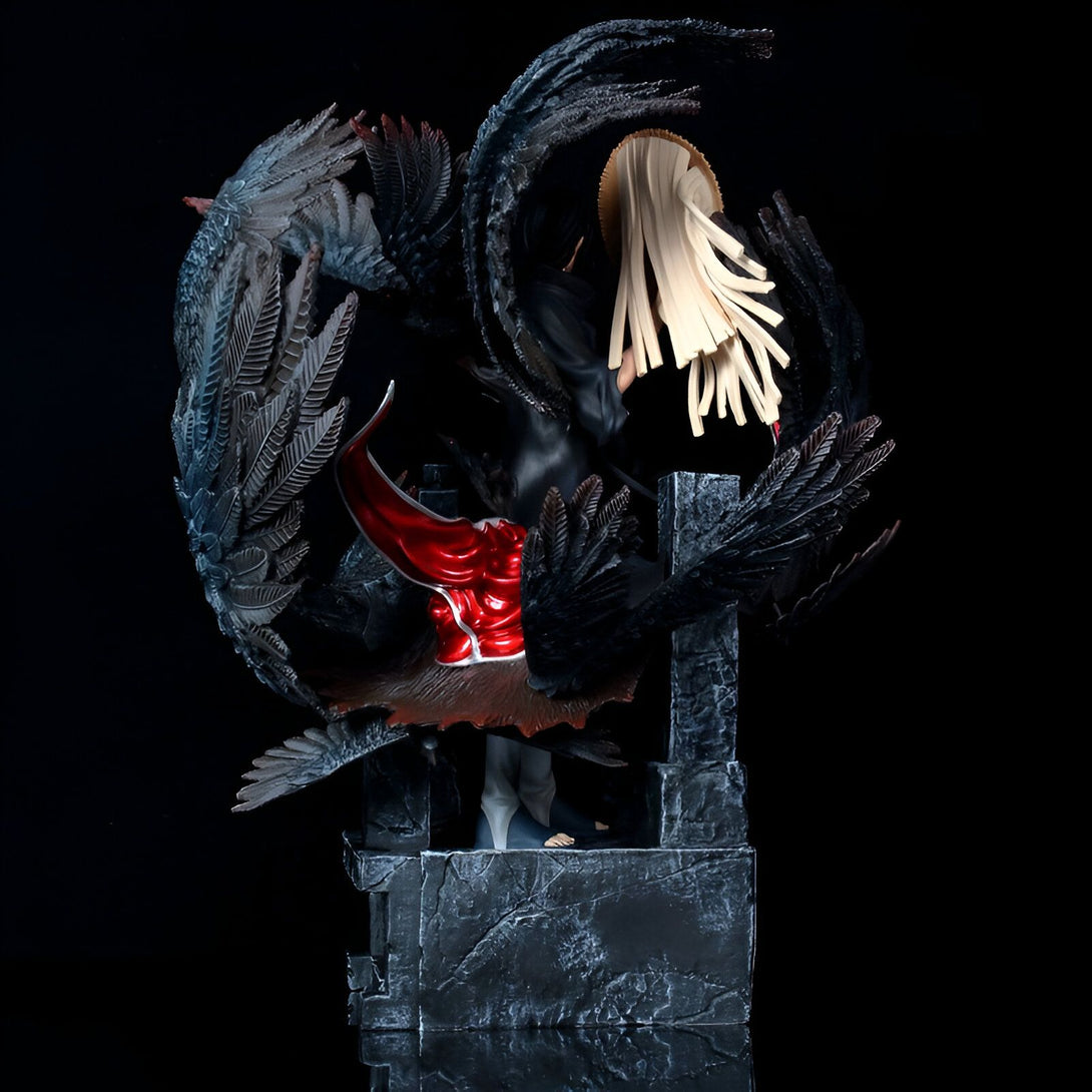 Statue de collection de Madara Uchiwa, un personnage de l'anime Naruto, debout sur un socle de pierre avec des ailes noires déployées.  Il est vêtu d'une tenue noire et rouge.