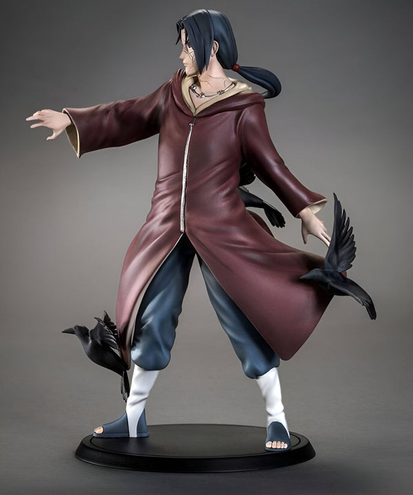 Statue de l'anime Naruto représentant le personnage d'Obito Uchiha, vêtu d'une longue robe rouge avec des corbeaux noirs à ses côtés. Il est positionné debout sur un socle noir, les bras tendus.