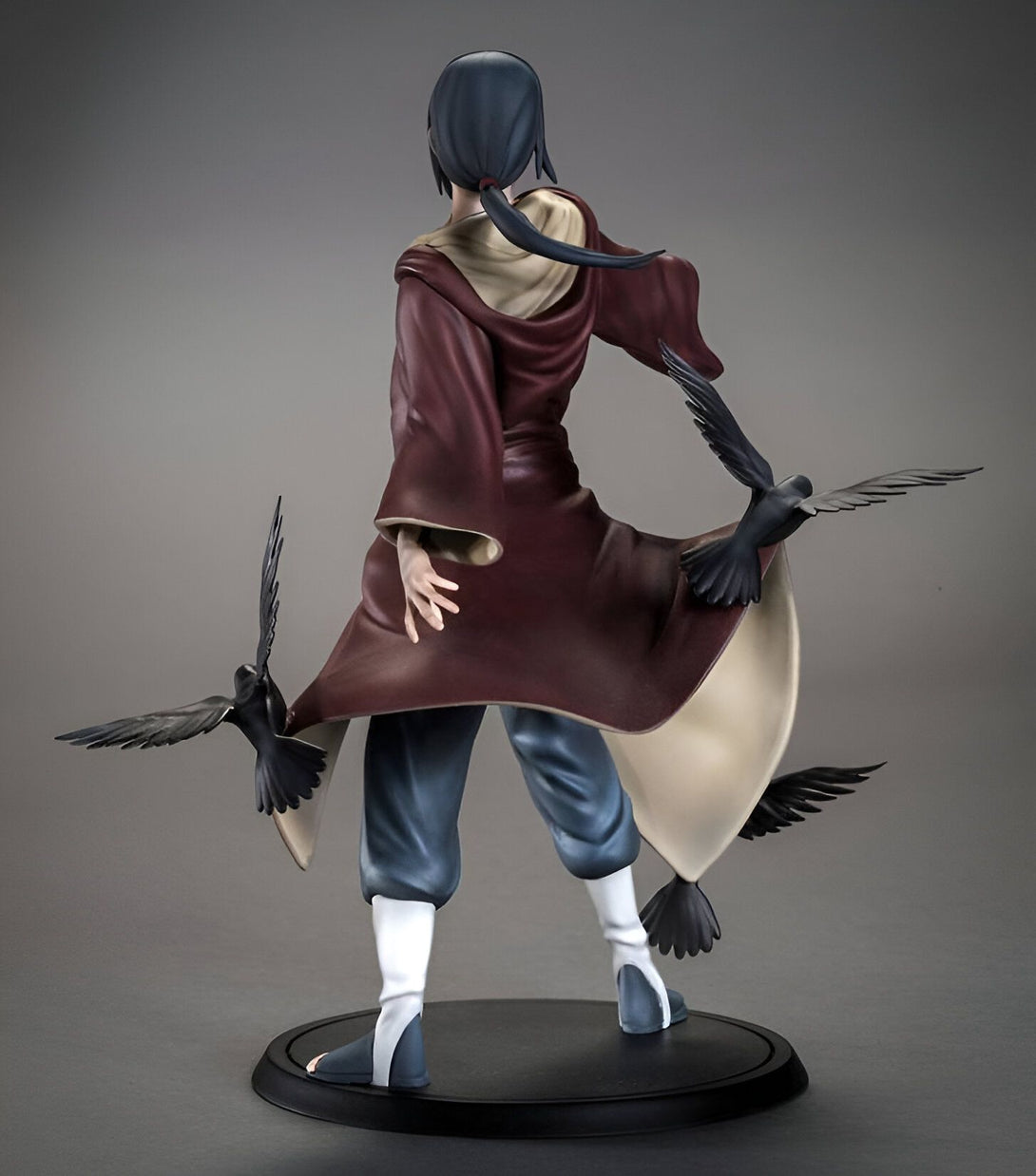 Statue de l'anime Naruto représentant le personnage de Pain, vêtu d'une longue robe rouge et noire avec des corbeaux noirs sur ses épaules et ses jambes.