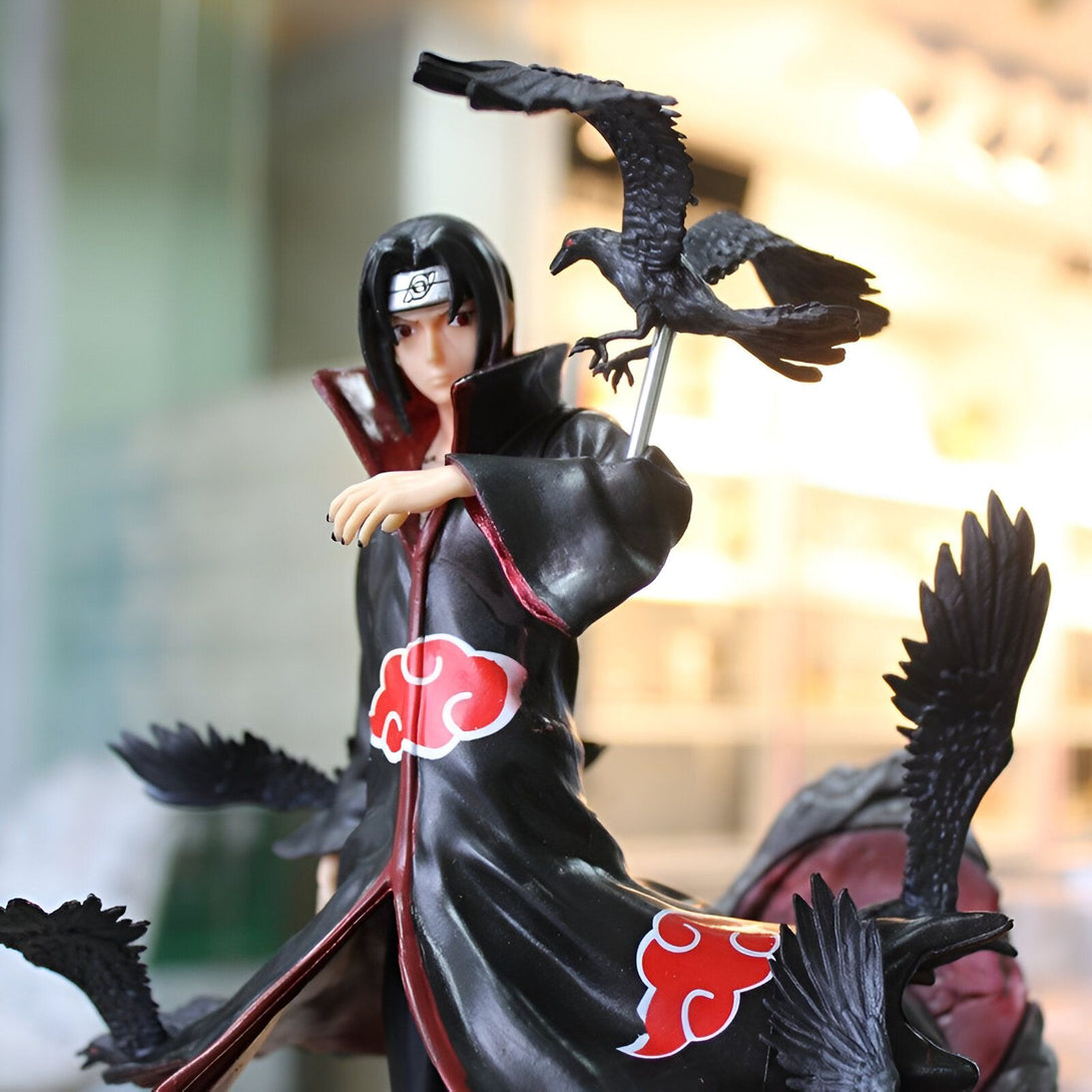 Figurine de Sasuke Uchiha de Naruto Shippuden, portant son emblématique manteau noir avec le symbole du Sharingan et entouré de corbeaux.