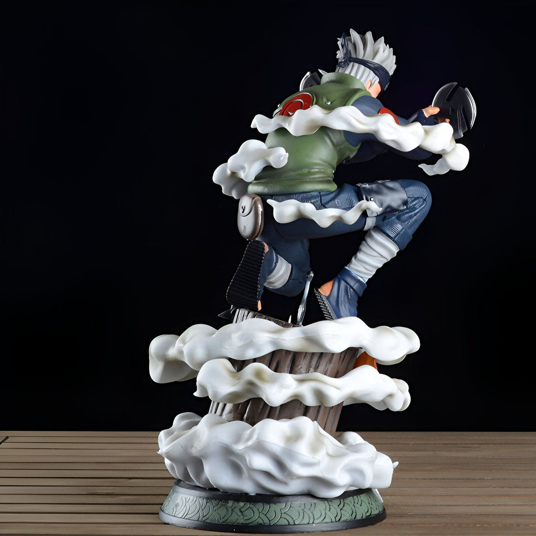 Figur de Kakashi Hatake de Naruto, en position d'attaque, avec des effets de fumée blanche, debout sur un tronc d'arbre.