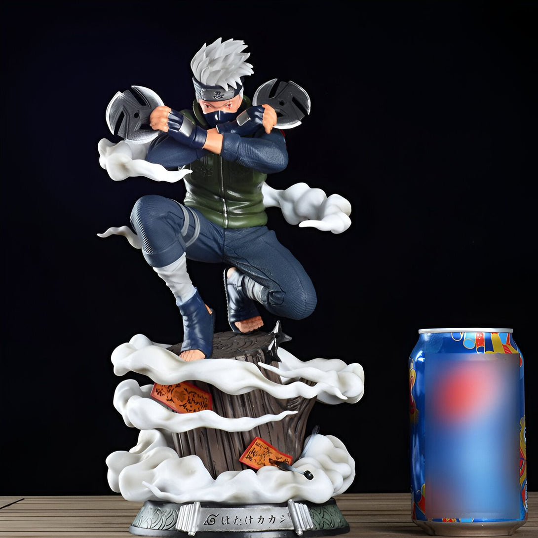 Statue de Kakashi Hatake du manga Naruto, représenté en train de lancer ses kunaïs, avec des effets de fumée et une base en bois. La statue est présentée à côté d'une canette de soda pour donner une idée de sa taille.