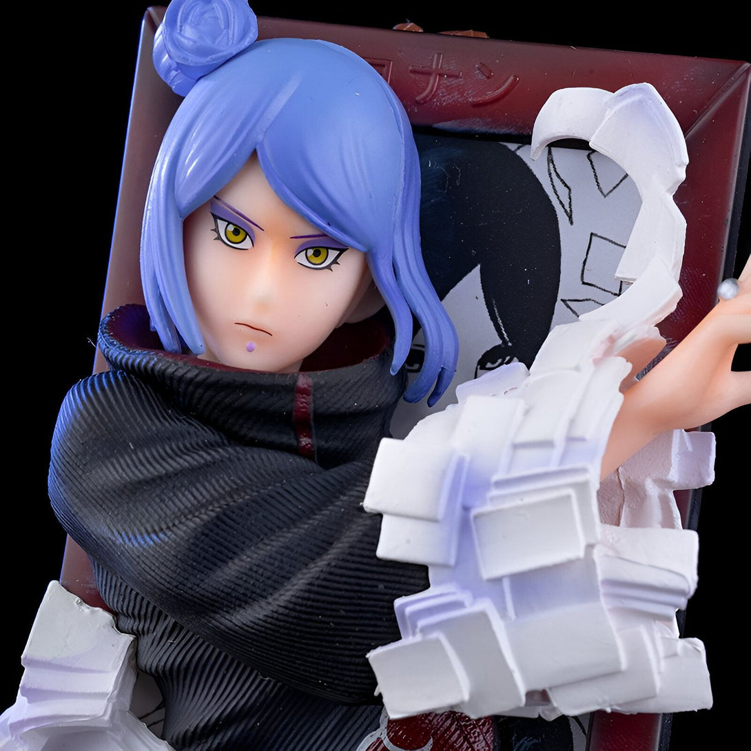 Figur de Konan, un personnage de l'anime Naruto, portant sa tenue de l'organisation Akatsuki. La figurine est représentée dans une pose dynamique, avec un regard intense et un visage menaçant. Elle tient une feuille de papier dans sa main, rappelant son pouvoir de manipulation du papier. La figurine est très détaillée, et capture parfaitement l'apparence de Konan dans l'anime.