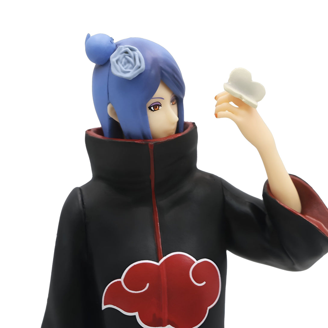 Figur de Konan de Naruto avec un costume noir et rouge, une fleur bleue dans les cheveux et une main tenant une feuille blanche.