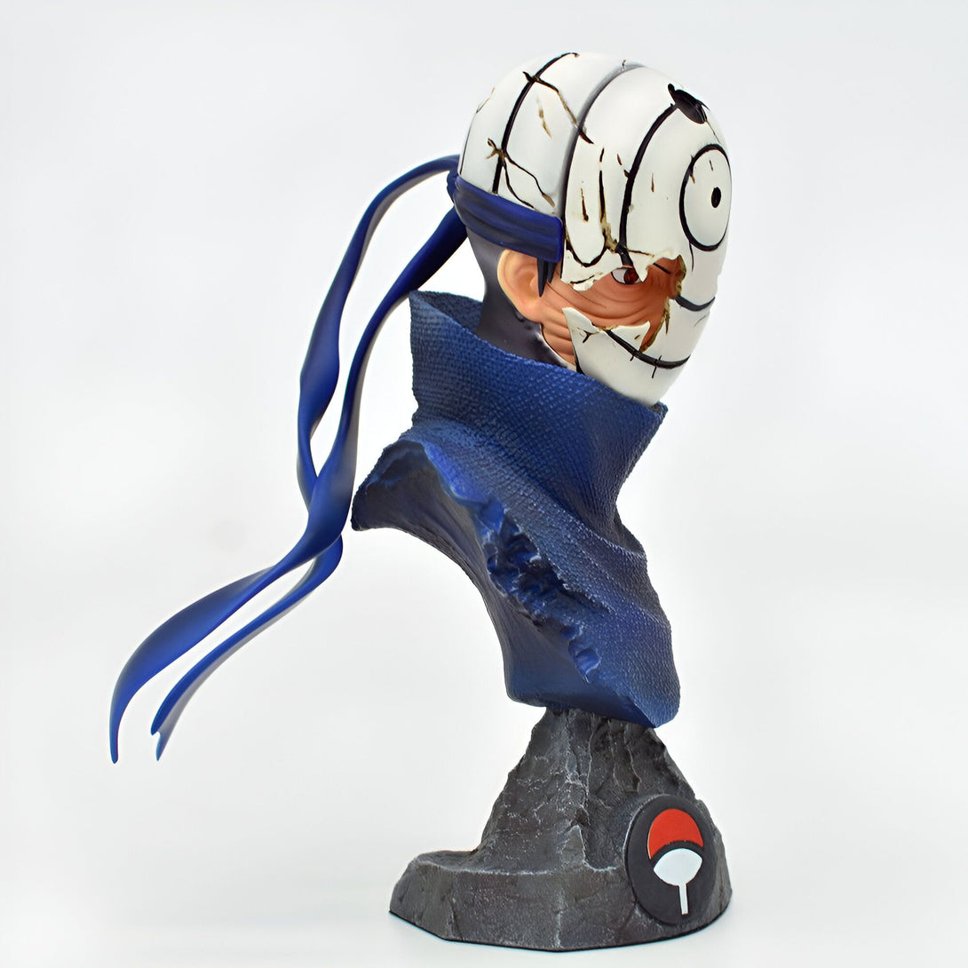 Buste de Obito Uchiha, personnage de l'anime Naruto, avec son bandeau et son Sharingan. La figurine est présentée sur une base de pierre avec le logo du village de Konoha.