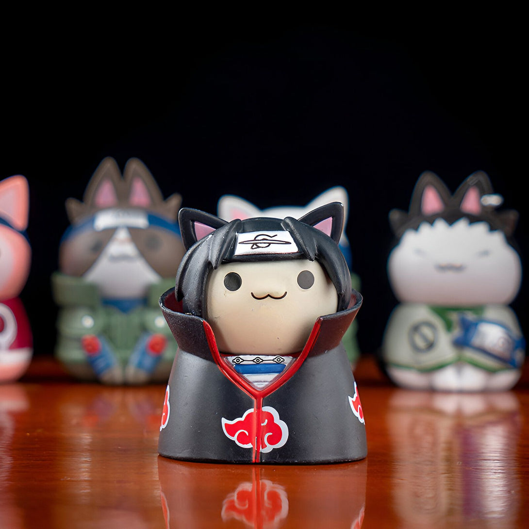 Figurine de chat Naruto en version Itachi Uchiha avec un bandeau rouge sur la tête et une cape rouge avec l'emblème d'Akatsuki.