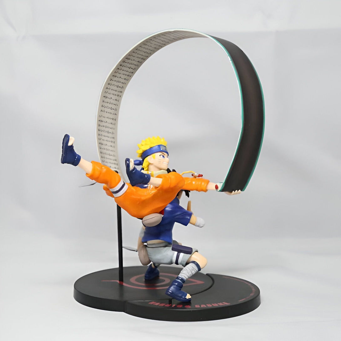 Naruto et Sasuke en figurine, se tenant l'un contre l'autre dans une pose dynamique, avec un fond noir et un symbole rouge. La figurine est de haute qualité et est un excellent ajout à toute collection de Naruto.