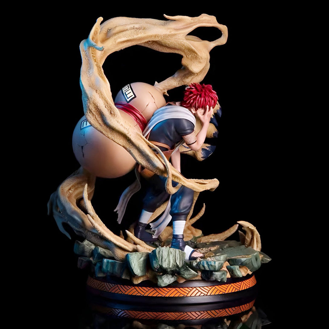 Statue de Gaara du manga Naruto, utilisant son pouvoir de sable pour se protéger. Il est en train de combattre avec une expression déterminée. La figurine est posée sur une base ornée de détails.