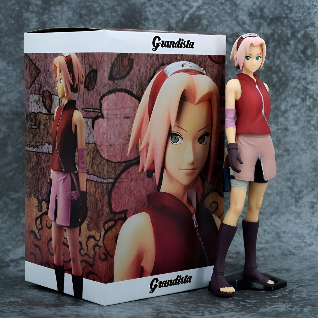 Figure de collection Grandista de Sakura Haruno de Naruto Shippuden, posant fièrement avec son costume rose et rouge.  La figurine est sur un socle et est livrée dans une boîte.
