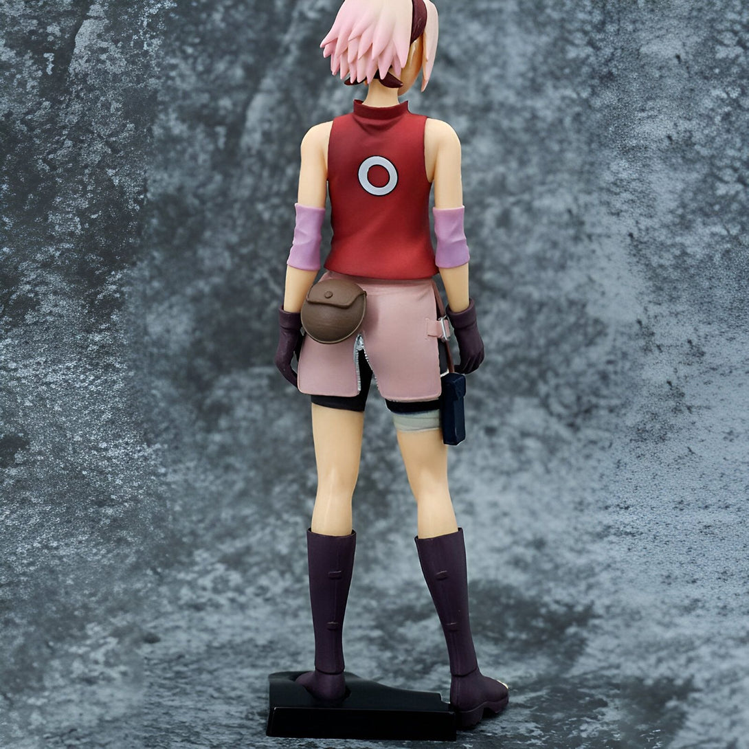 Figure de Sakura Haruno de Naruto, vue de dos, portant sa tenue de ninja rose et rouge, avec ses cheveux roses et un bandeau.