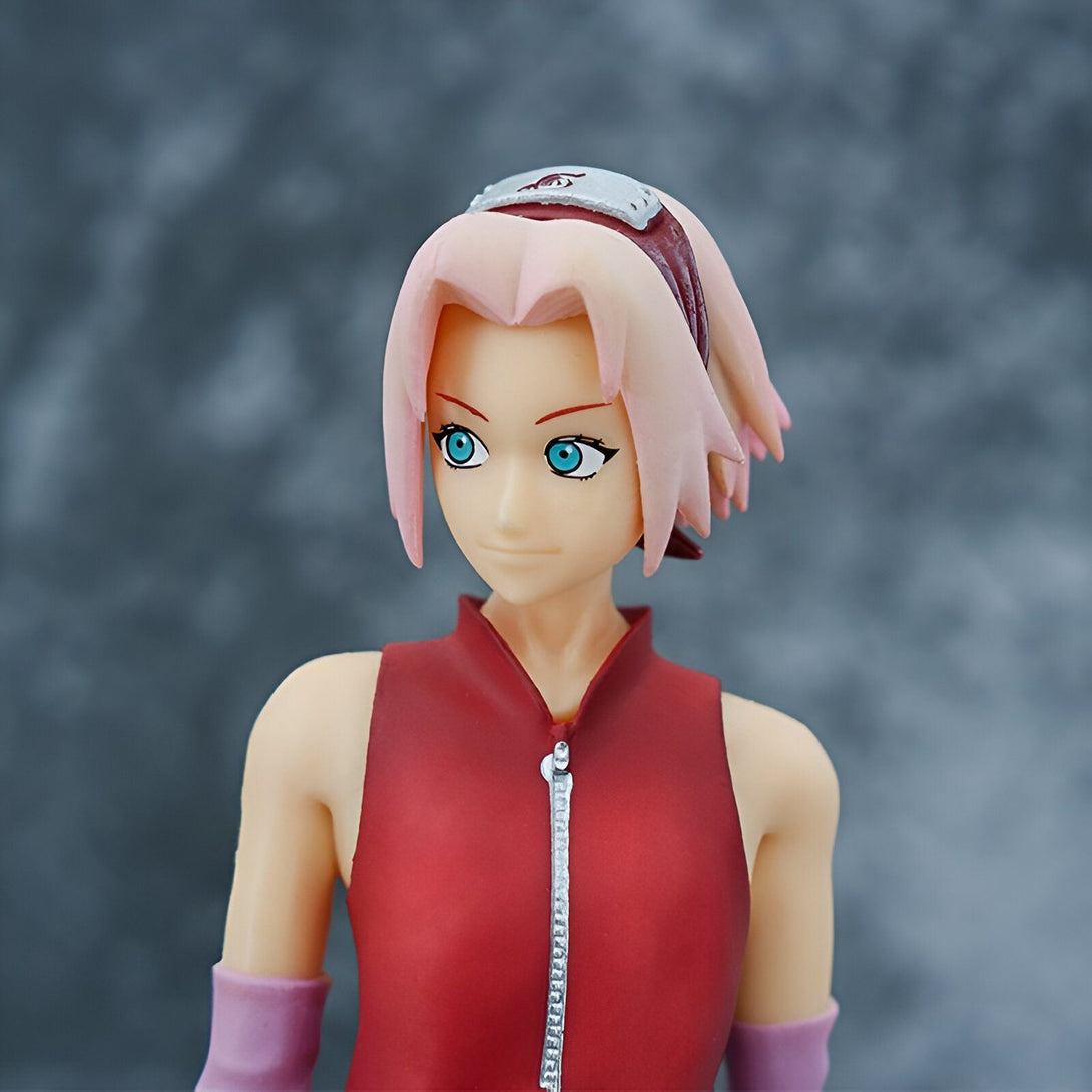 Figure de Sakura Haruno, personnage de l'anime Naruto, portant sa tenue rose et rouge emblématique et son bandeau frontal avec le symbole du village de Konoha.