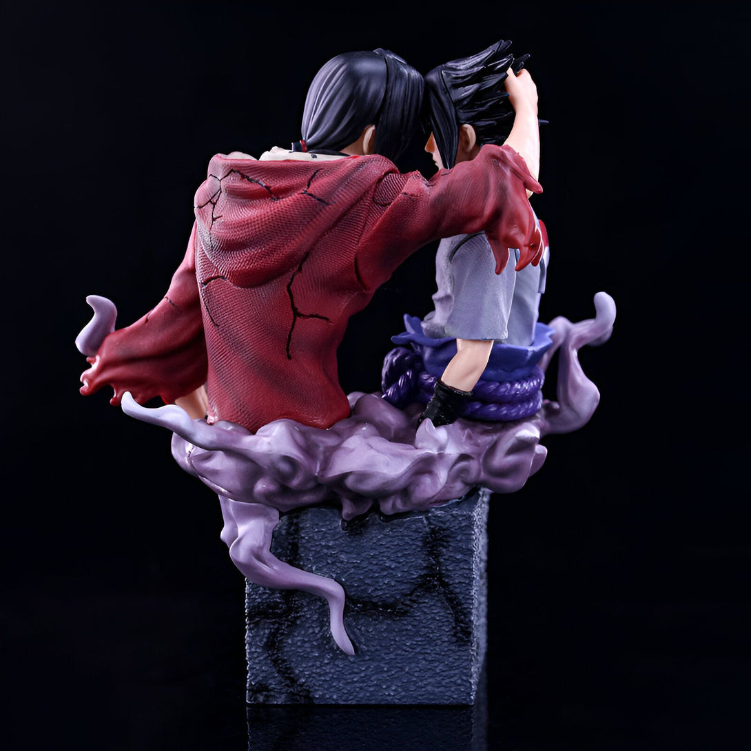 Figurine Naruto Shippuden représentant Sasuke et Itachi dans une pose d'embrasement, Sasuke en tenue noire et Itachi avec son manteau rouge, posés sur un socle gris.