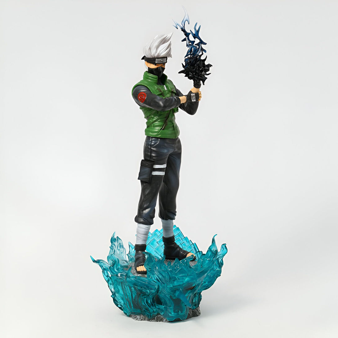 Figurine de Kakashi Hatake de Naruto Shippuden debout sur une base bleue avec un effet de vent. Il porte son bandeau frontal et son armure verte.
