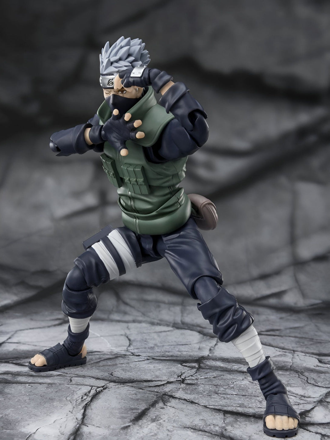 Figure d'action de Kakashi Hatake de Naruto Shippuden, prêt au combat, avec son bandeau frontal et sa tenue verte caractéristique.