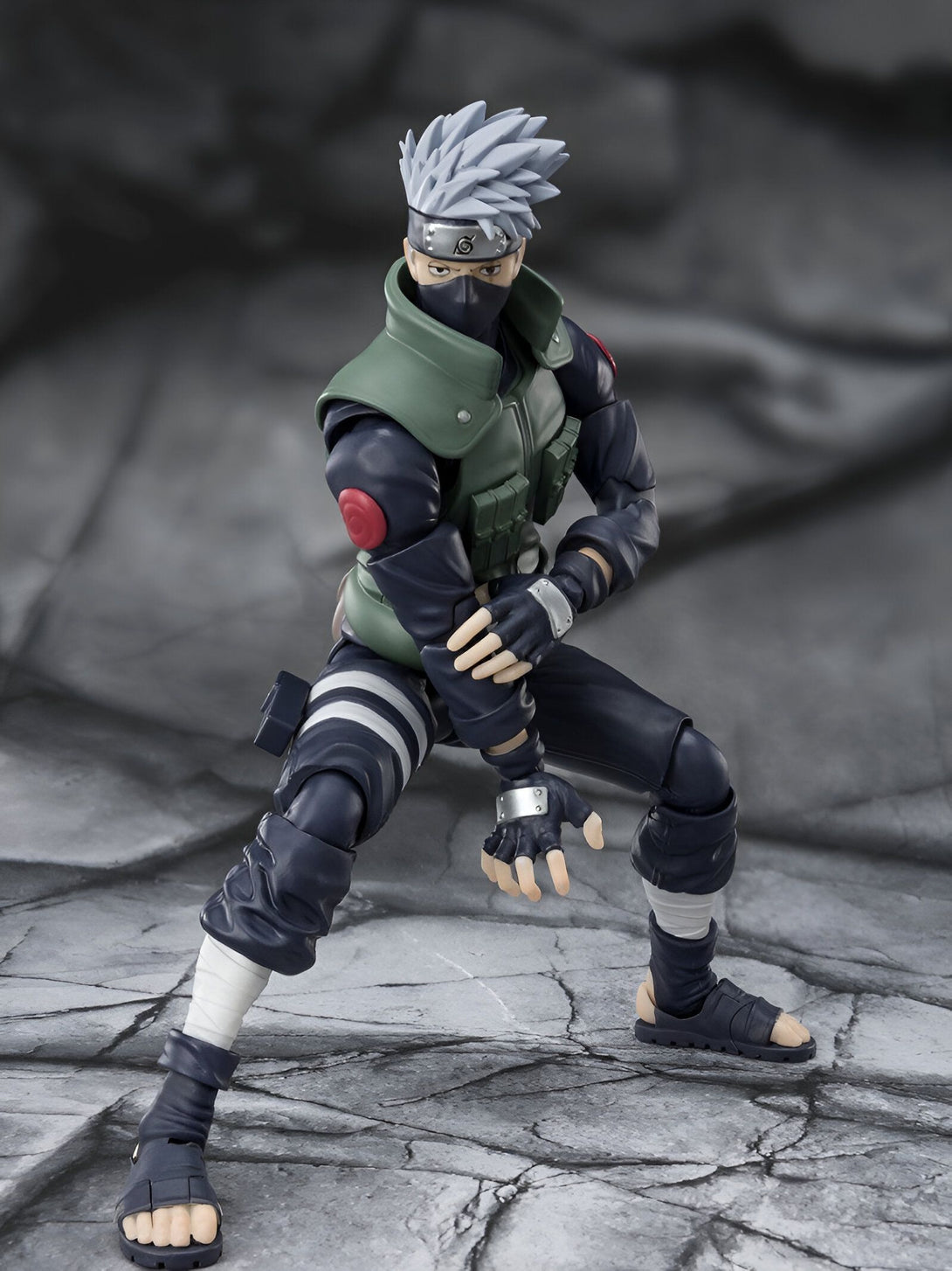 Figure articulée de Kakashi Hatake de la série Naruto Shippuden, portant son costume vert et noir emblématique, avec ses cheveux argentés, son bandeau frontal et son masque.