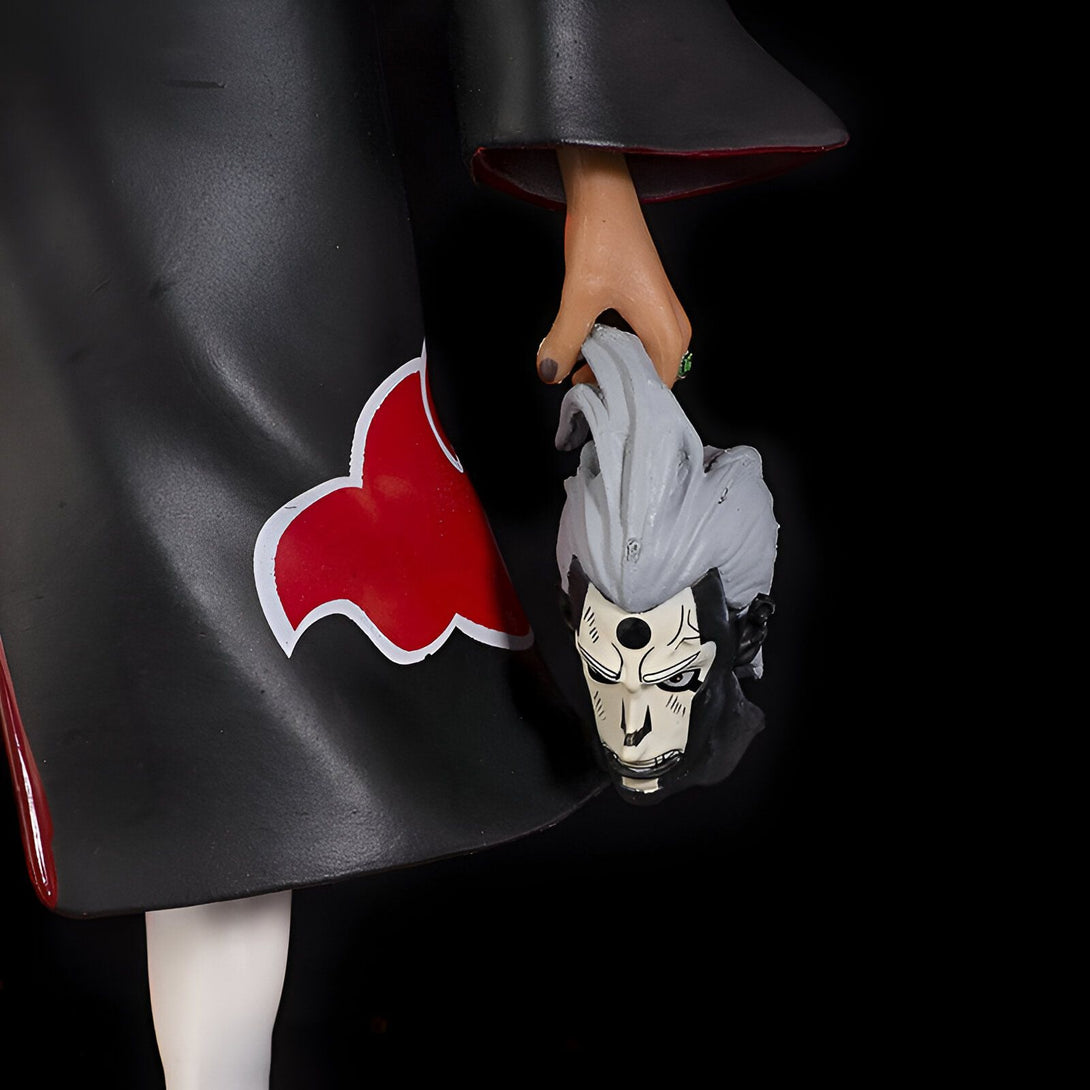 Une figurine de Naruto représentant Pain, un personnage portant un long manteau noir avec un symbole rouge sur la manche, tenant la tête décapitée de Jiraiya dans sa main droite.
