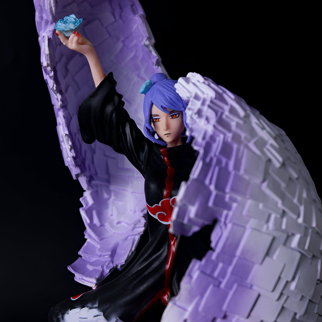 Figurine de Konan de Naruto Shippuden, avec ses ailes violettes et blanches, tenant un cristal bleu.  Elle est représentée dans une pose dynamique, prête à attaquer.  Parfait pour les fans de Naruto.