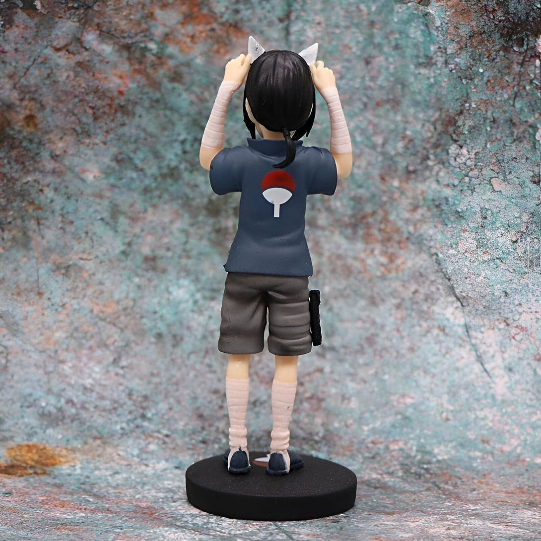Figurine de Naruto portant un T-shirt bleu avec l'emblème du village de Konoha et des bandages blancs aux poignets, avec des oreilles de chat blanches. Il est debout sur une base noire.