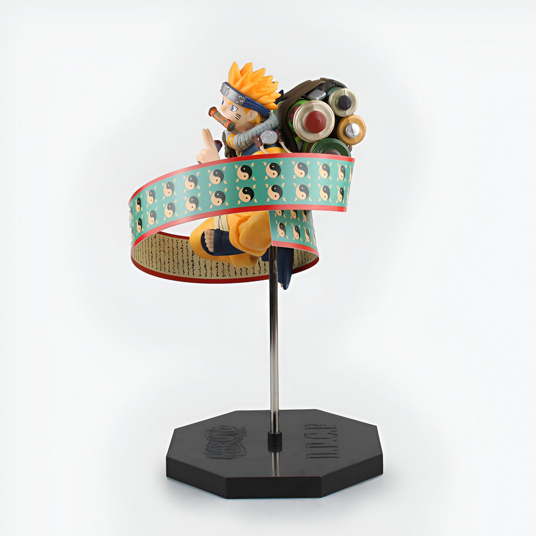 Naruto, le personnage principal de l'anime Naruto, en figurine, dans une pose de méditation, entouré de ses scrolls et d'un symbole Yin Yang.