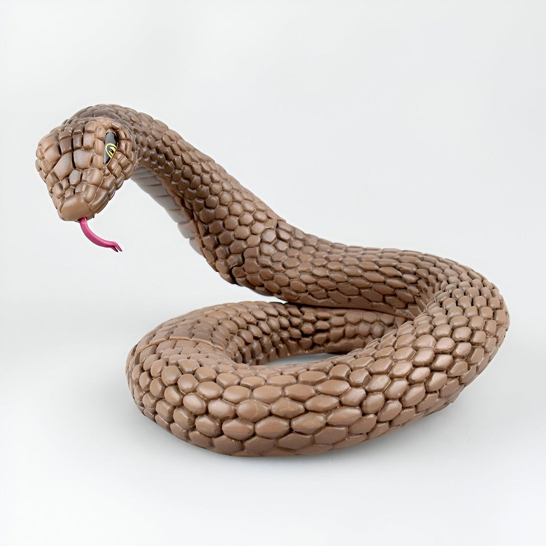 Un serpent en plastique brun foncé, enroulé sur lui-même, la tête levée et la langue fourchue sortie.