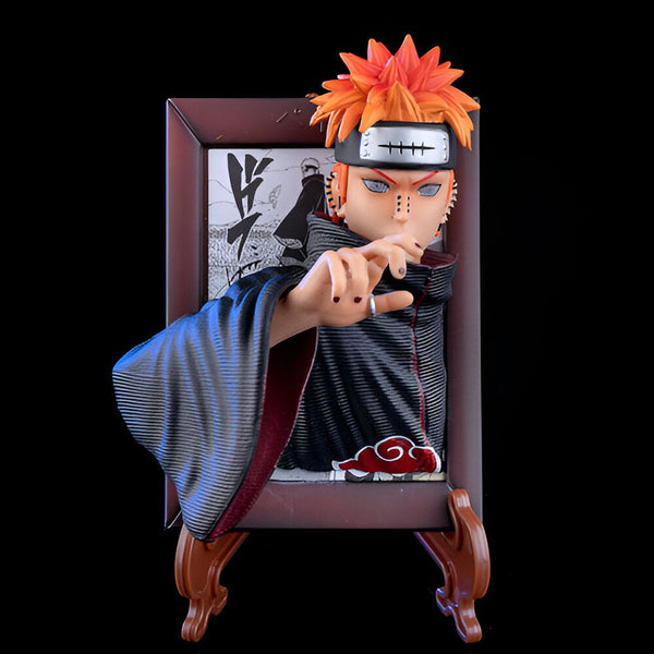 Statue de Pain, un personnage de l'anime Naruto, dans un cadre en bois. Il porte sa tenue rouge et noire et son headband Akatsuki avec le logo de l'organisation. La figurine est représentée avec un geste de main.
