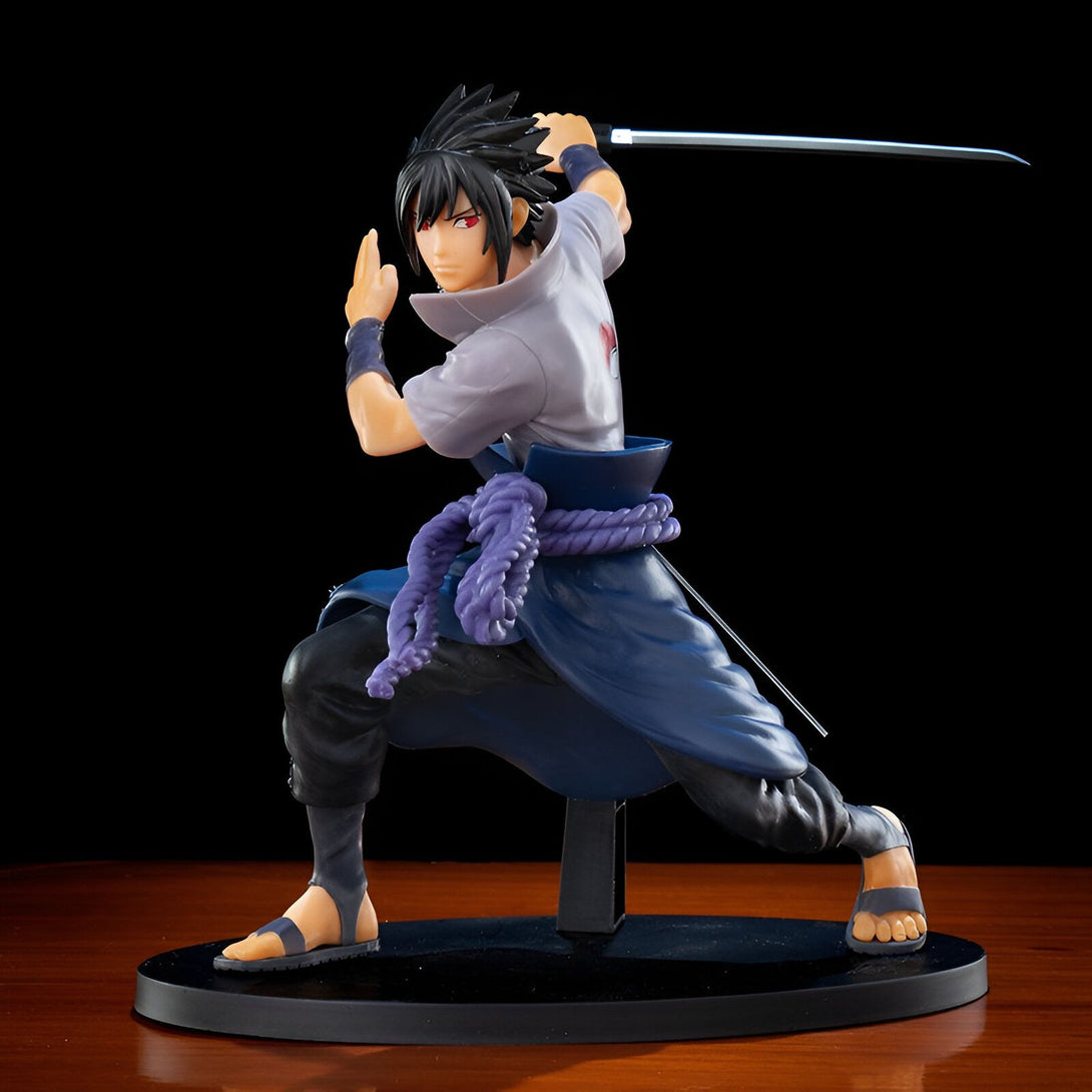 Figurine de Sasuke Uchiha de Naruto Shippuden en position d'attaque, tenant son épée. La figurine est représentée avec un grand soin du détail, des vêtements aux accessoires.
