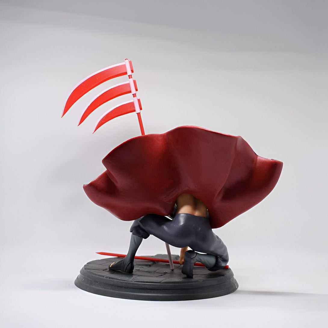 Figure de Naruto avec une cape rouge et un drapeau rouge et blanc. La figurine est posée sur une base noire. Figurine de collection Naruto.