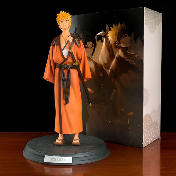 Naruto en tenue traditionnelle japonaise, tenant un katana et portant un kimono orange. La figurine est livrée avec une boîte en carton illustrée de différents personnages de l'anime.