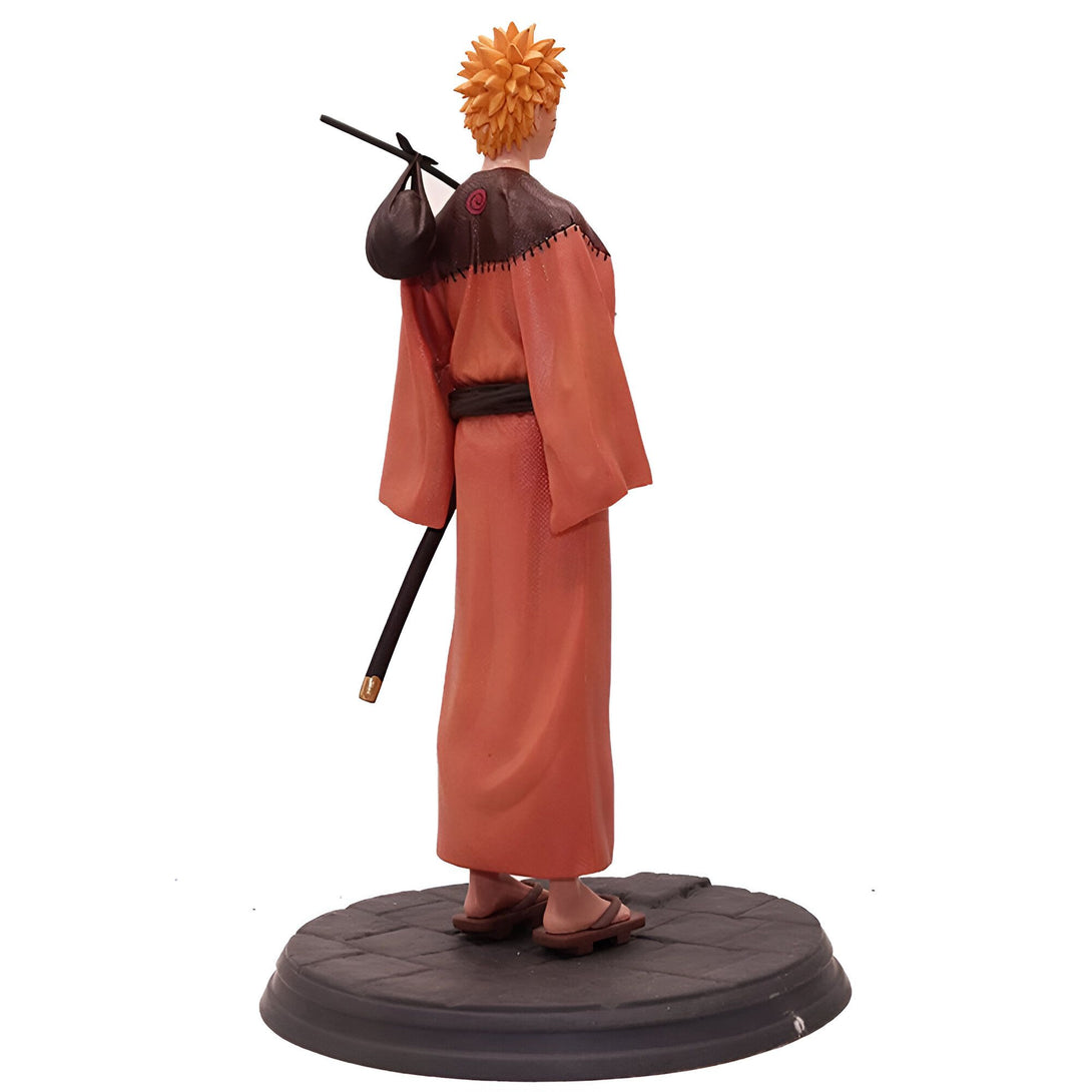 Naruto Uzumaki, personnage principal de l'anime Naruto, portant un kimono orange et un sac sur son épaule, debout sur un socle en pierre, figurine de collection.