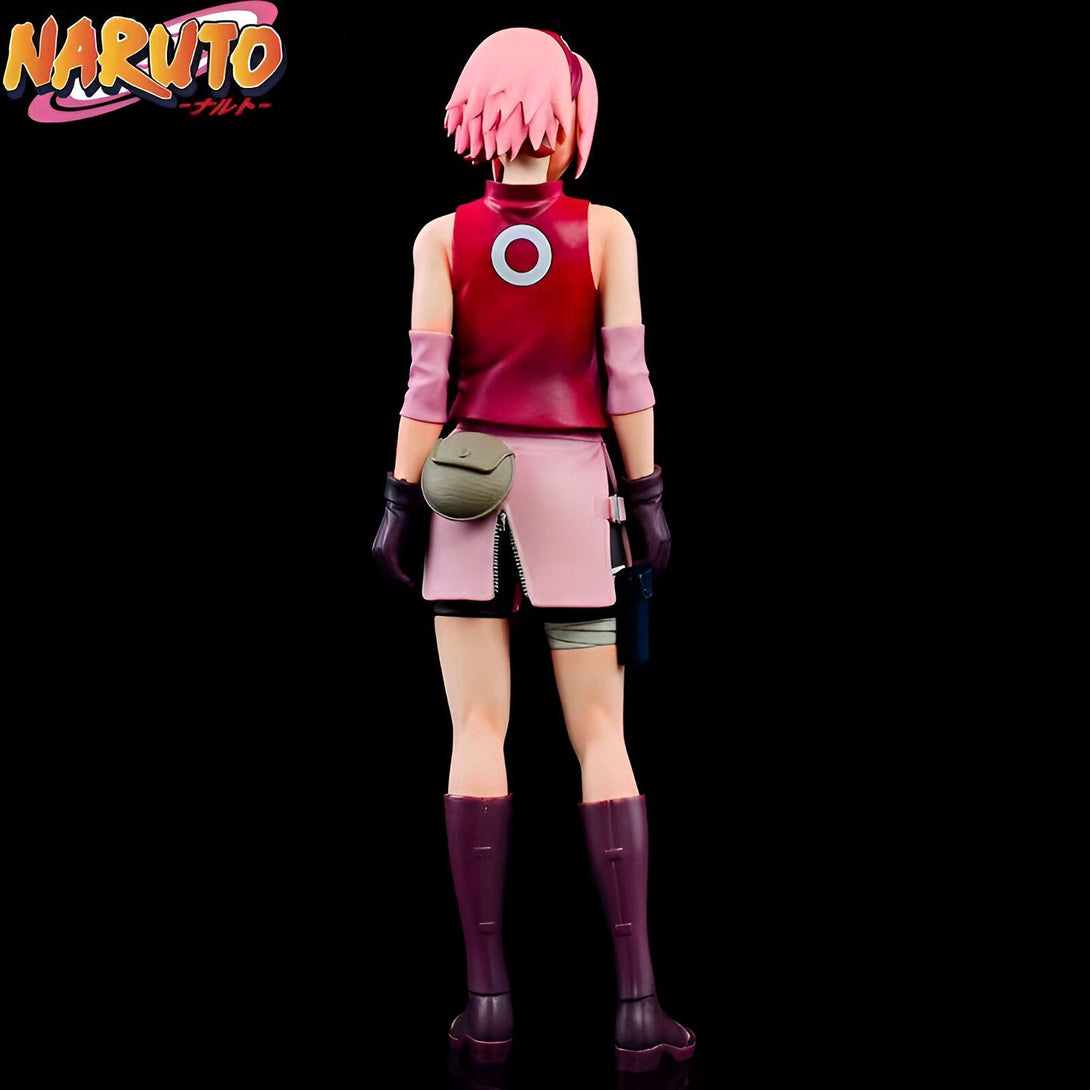 Figurines Naruto - Sakura Haruno en tenue de combat, vue arrière. Elle porte une jupe rose, un gilet rouge et des bottes violettes.