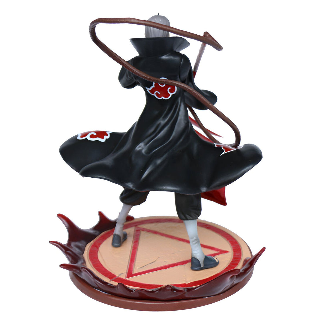 Figurines Naruto Shippuden Pain avec son manteau rouge et noir, tenant une arme à sangle, debout sur un socle en forme de cercle avec un triangle à l'intérieur, entouré de flammes rouges.