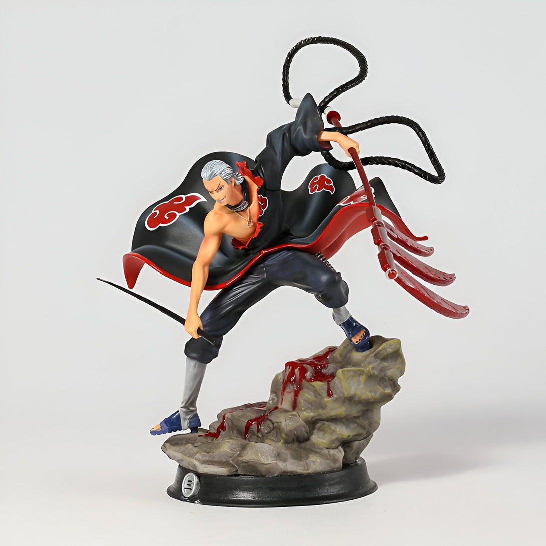 Figurine de Pain du manga Naruto, avec son manteau rouge et noir et ses armes, debout sur un rocher.  Il est prêt à attaquer avec son arme et sa posture agressive.  Une figurine de collection pour les fans de Naruto.