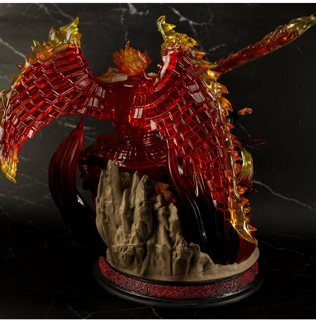 Statue de Naruto en PVC représentant le personnage de Sasuke avec ses ailes déployées en mode Susanoo. La figurine est posée sur un socle de roche avec des détails complexes.