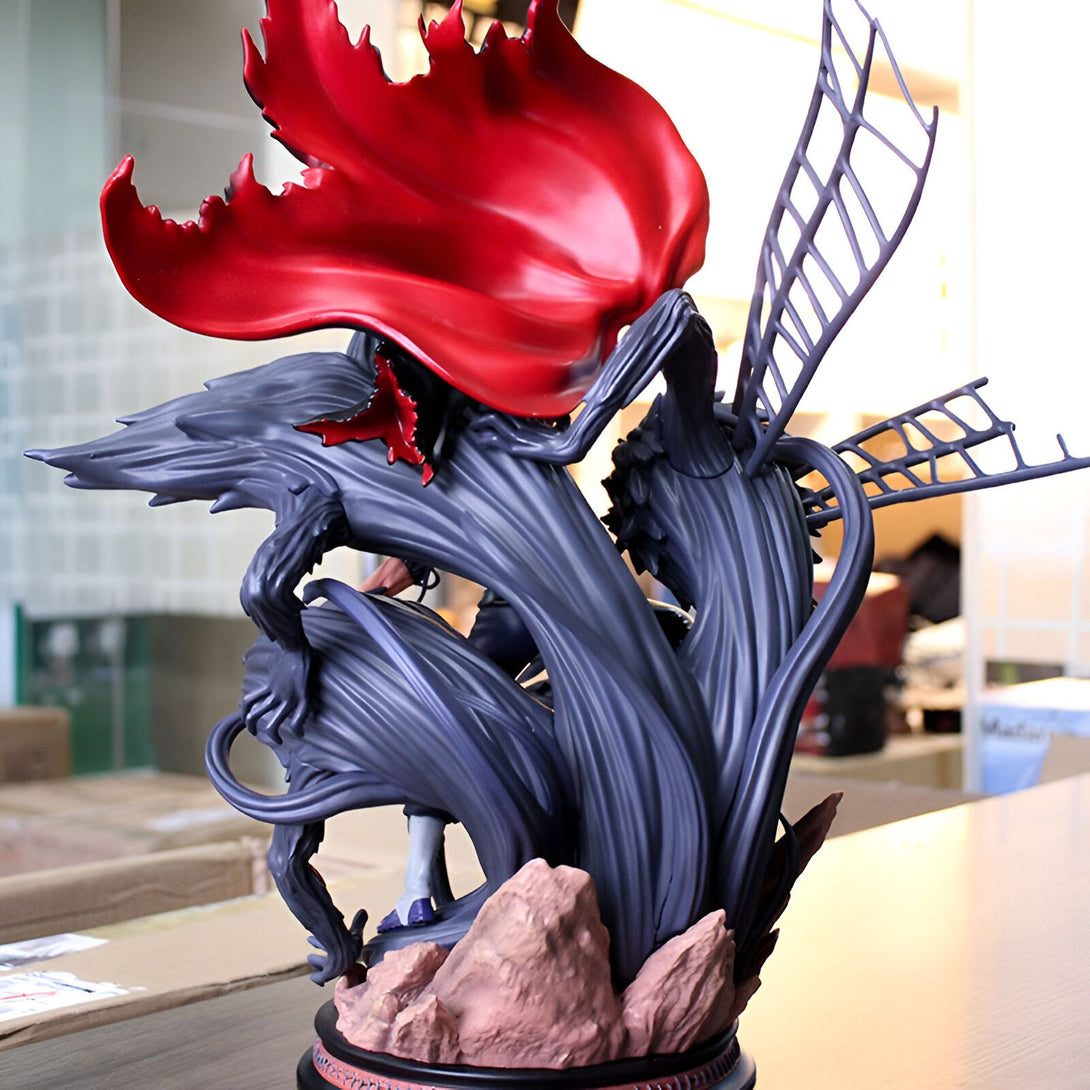 Statue de Naruto en PVC représentant Naruto Uzumaki dans son mode Kurama avec un manteau rouge flottant. La figurine est posée sur une base de rocher et des effets spéciaux en PVC gris simulent son chakra.