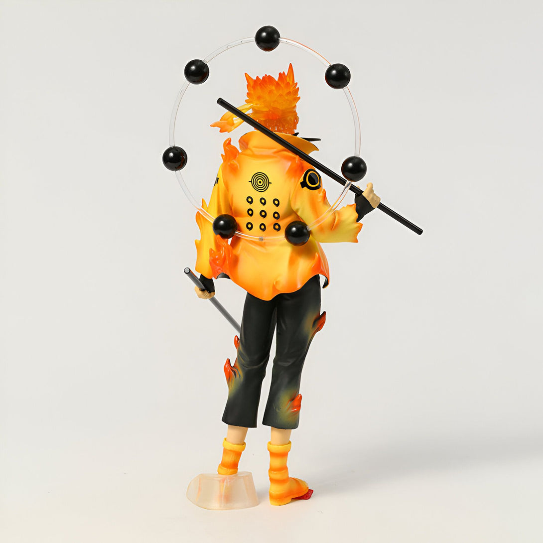Figure de Naruto Uzumaki en mode Kurama, avec un manteau jaune et des flammes orange, tenant un bâton. Il est entouré d'un cercle transparent avec six sphères noires.