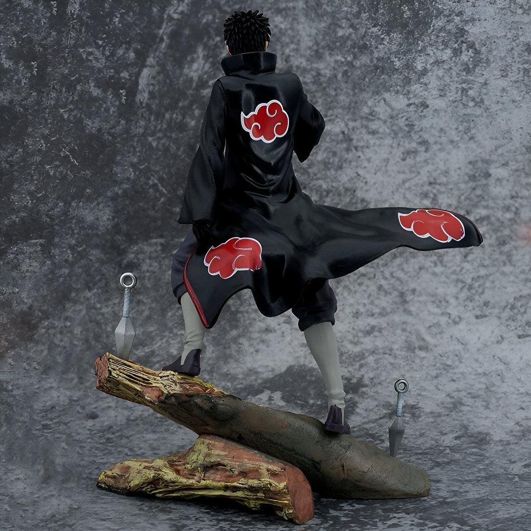 Figure de collection de Pain de Naruto Shippuden,  en position debout,  sur une base en bois, avec deux kunais à ses côtés. Le personnage porte son manteau rouge emblématique avec le symbole de l'Akatsuki.