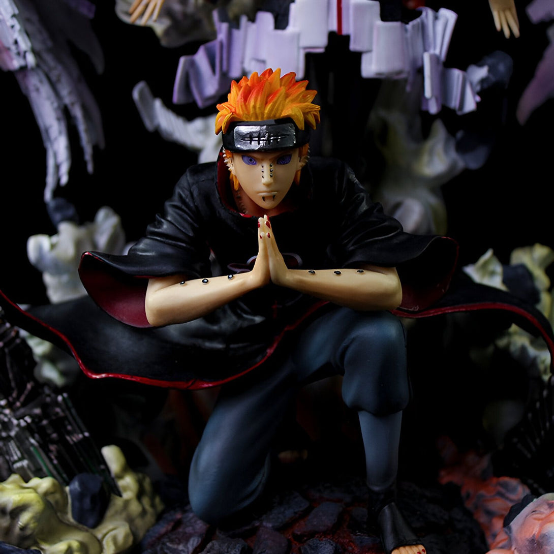 Figur de Pain de Naruto en position de méditation, avec ses bras croisés sur ses genoux, le regard fixe et intense. Il porte son manteau rouge et noir caractéristique.