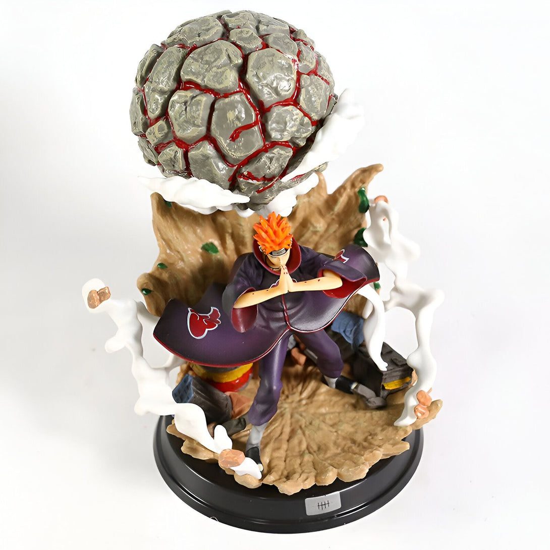 Figurine de Pain du manga Naruto, représentant le personnage dans sa tenue rouge et noire avec une sphère de roche flottant au-dessus de lui. La figurine est posée sur un socle noir.